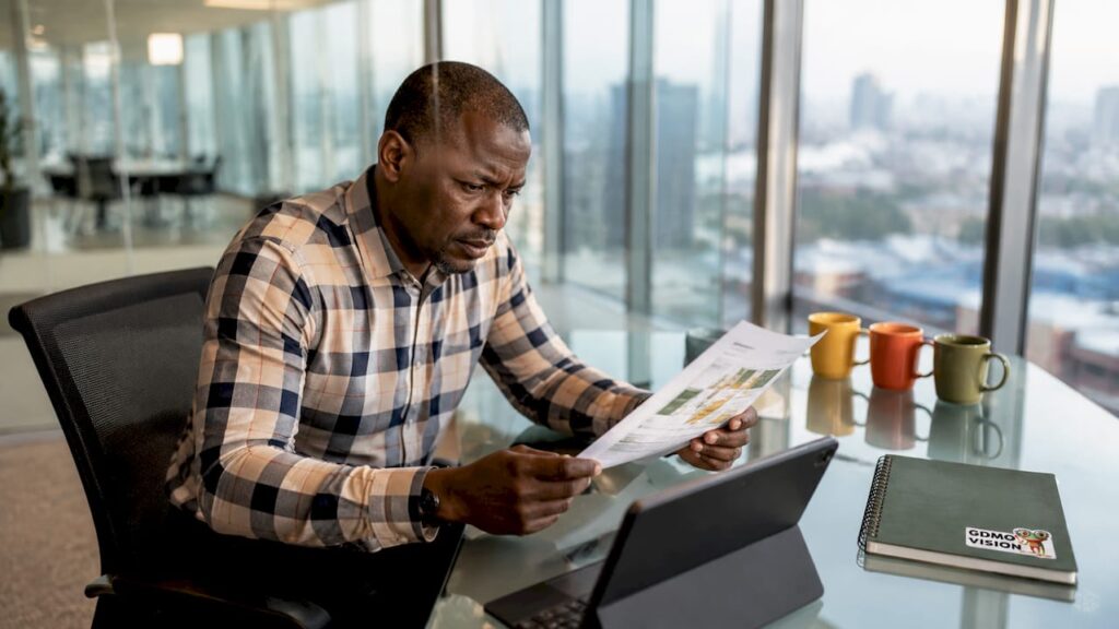 Un chef d'entreprise en pleine lecture de son plan d'action dans son bureau