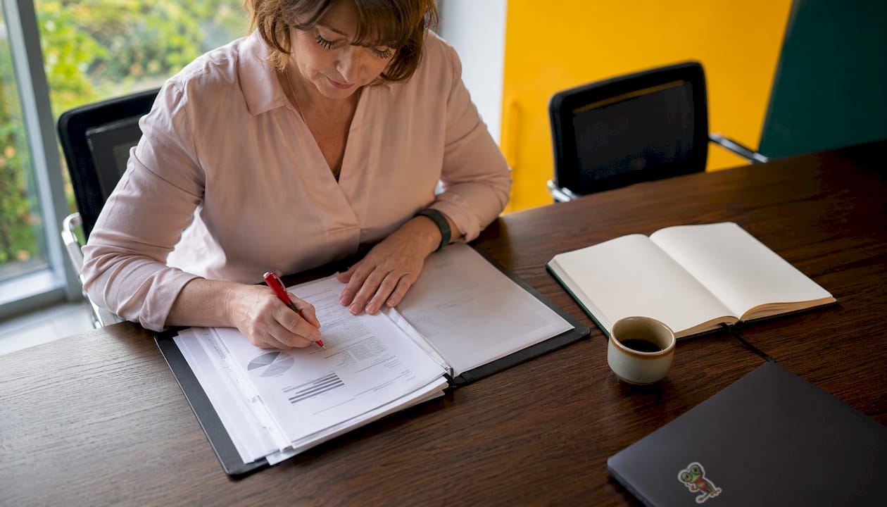 Des mains en train de prendre des notes sur des documents dans le cadre d’un audit